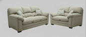 Beige sofa and love seat set with toss pillows on a plain background
